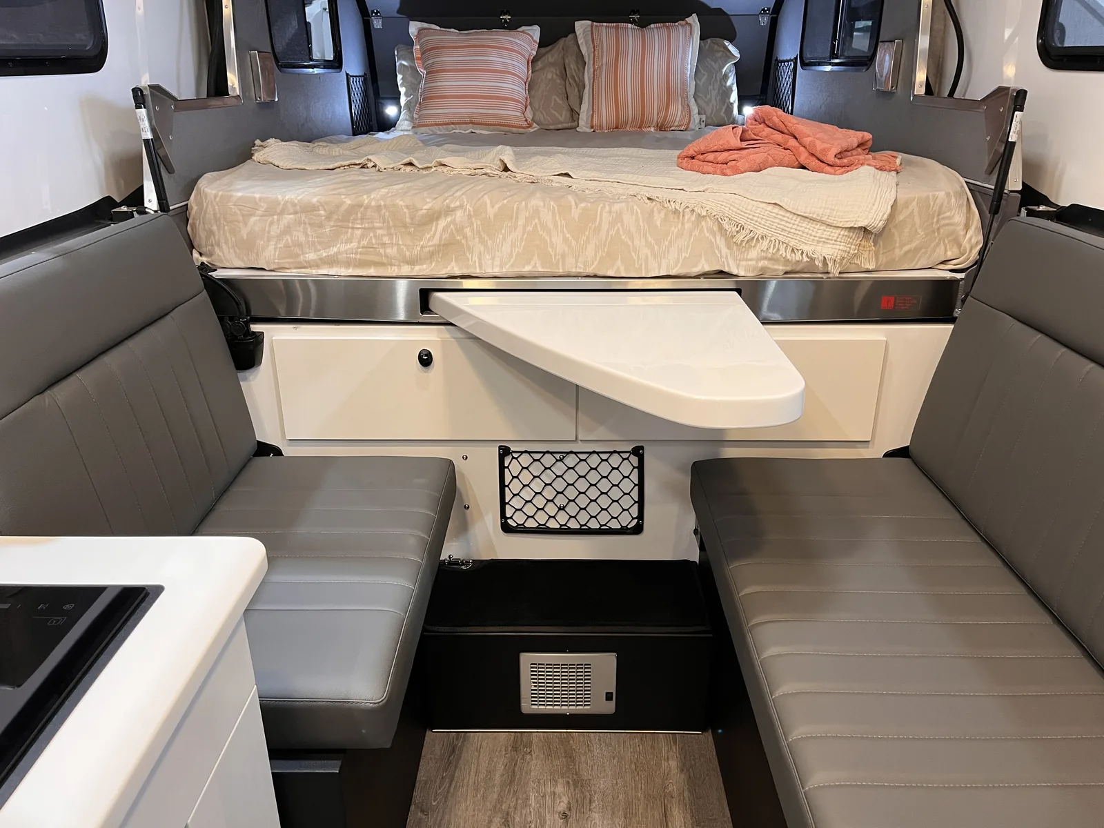 Karavan interior with queen bed, dinette and slide-out table