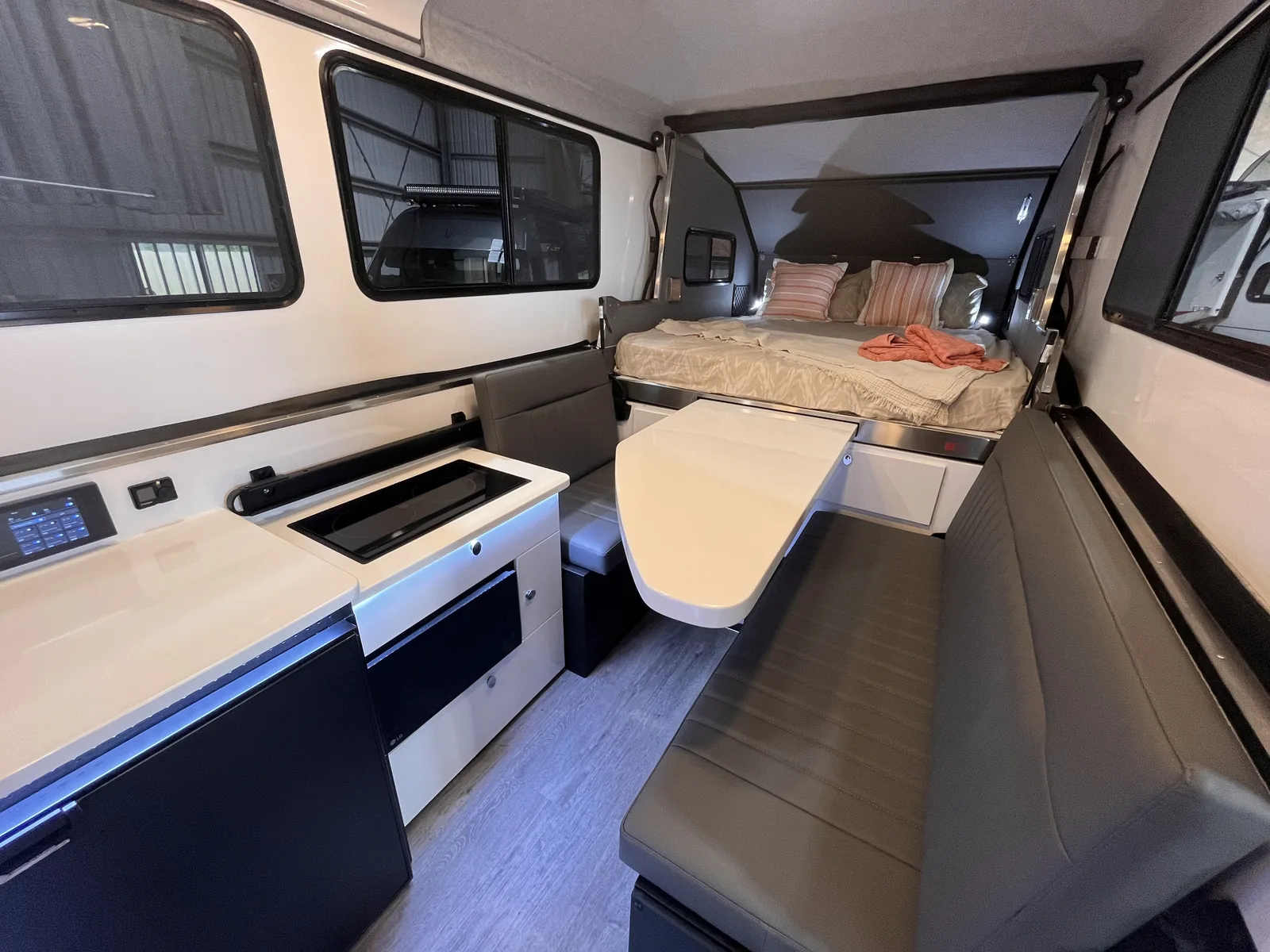 Wider interior view showing the kitchen bench, lounge and queen bed