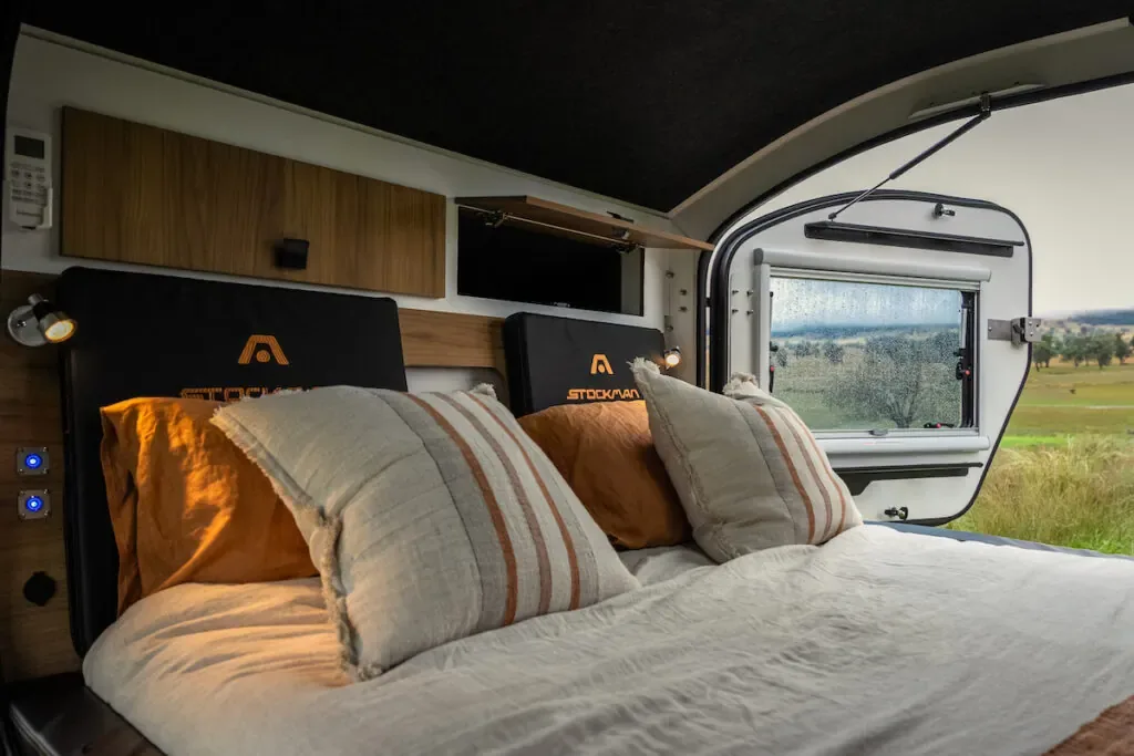Inside the Stockman Rover - queen inner-spring bed with a view out the window