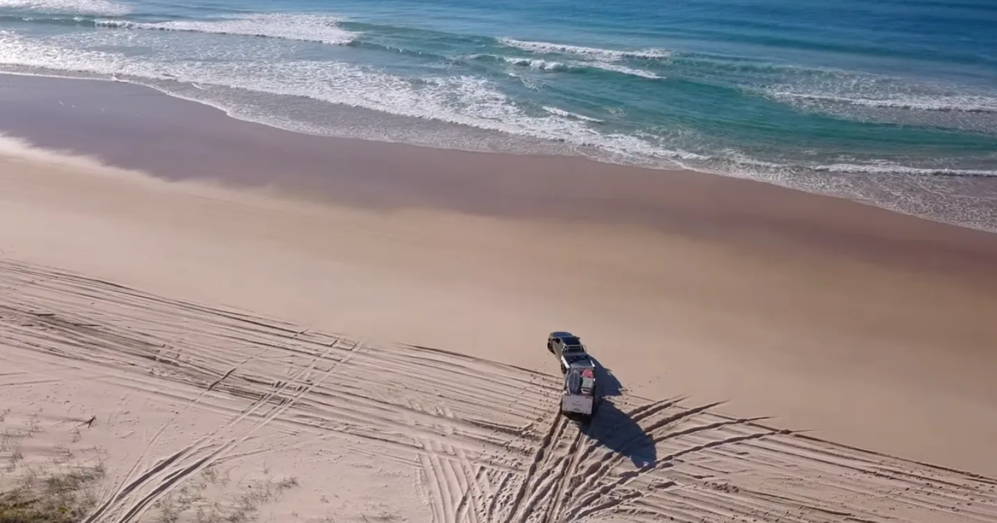 Stockman Rover towed along the beach beside the surf